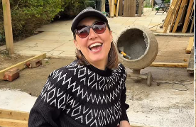 Content creator wearing headphones speaking into a microphone during a home renovation and DIY podcast interview.